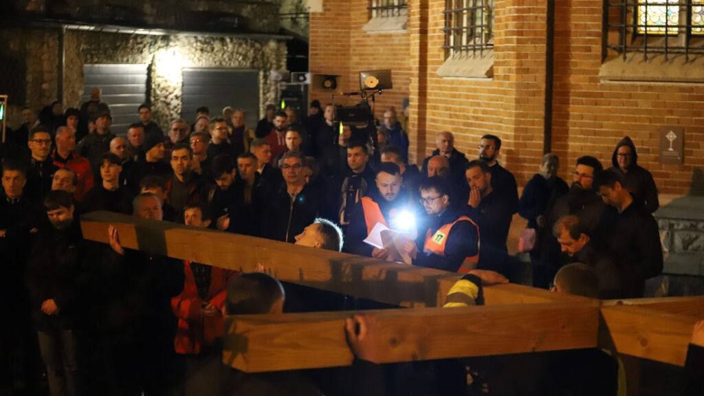 Mężczyźni niosą krzyż podczas Męskiej Drogi Krzyżowej ulicami Krakowa